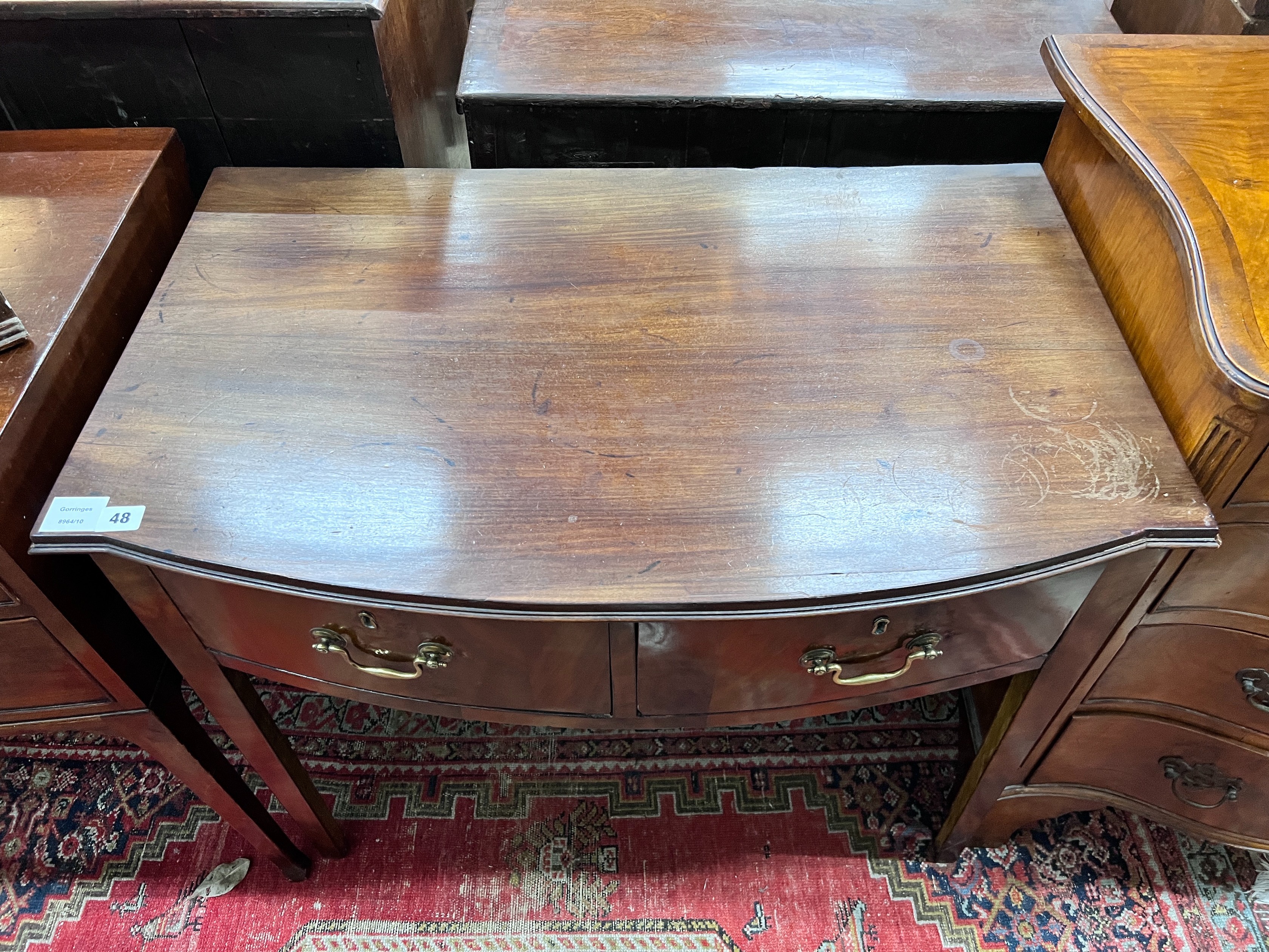 A George III mahogany bowfront two drawer side table, width 86cm, depth 54cm, height 74cm *Please note the sale commences at 9am.